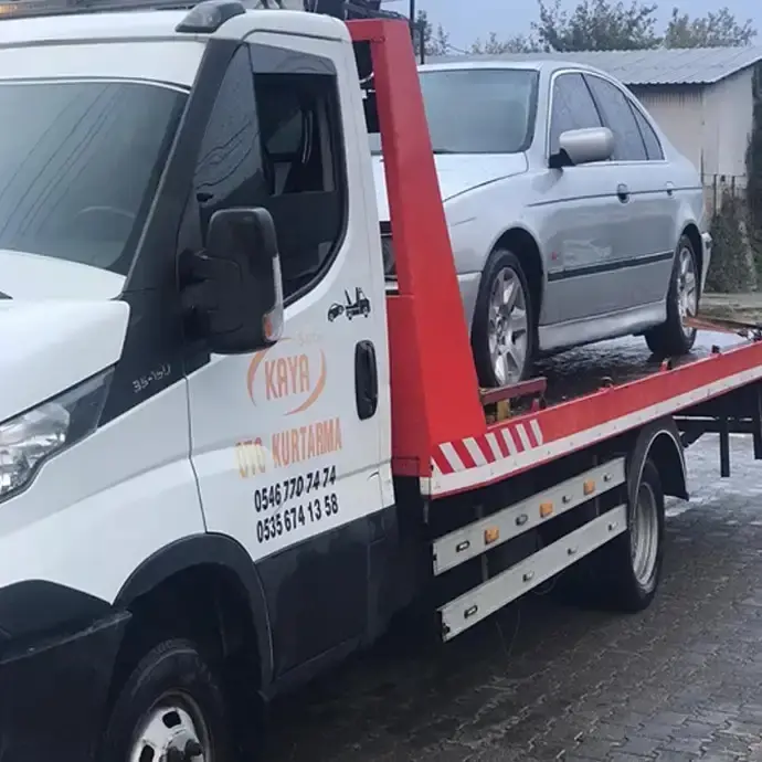 Kaya Oto Kurtarma yazılı çekici, kasasında gri bir otomobil